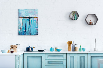 interior of modern kitchen with painting on white brick wall