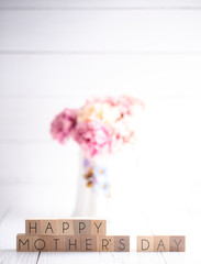A Mothers Day Background with Writing on Block Letters with Pink Flowers in a Vase