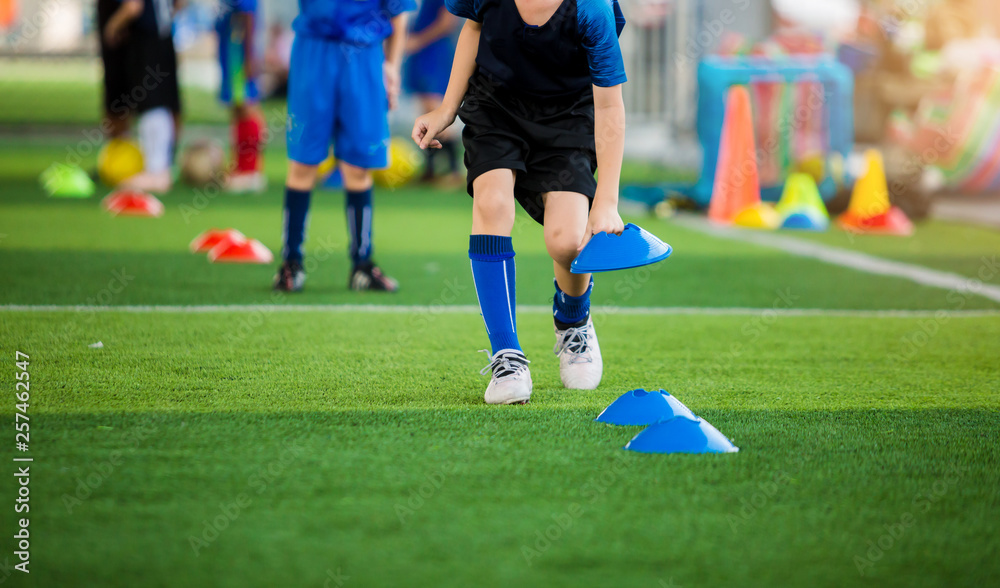 Wall mural selective focus to kid soccer player mark blue cone marker