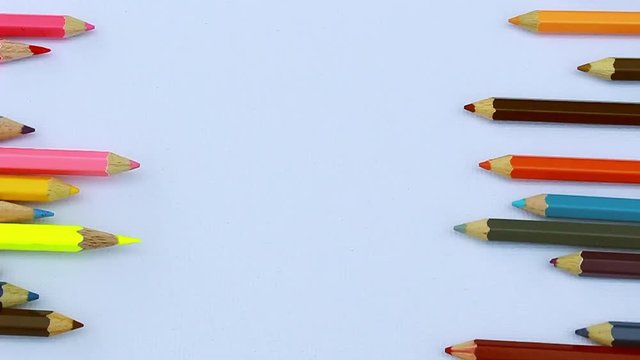 Close up of colorful pencils are rolling on white paper background. with copy spaces.