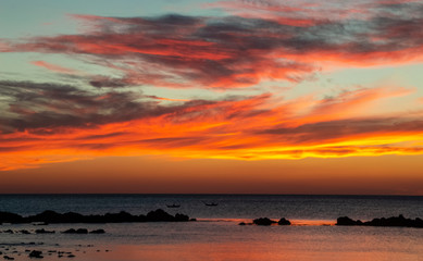 Fototapeta na wymiar Orange sunset on sea with boats