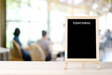 Today’s menu blackboard, sign board, on table at  blur coffee shop, restaurant, with people background, Blank chalkboard mock up background, food and drink background concept