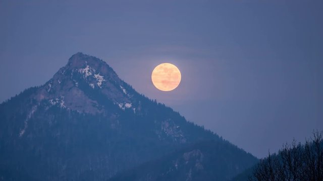 Full moon fall down over forest mountains Time lapse