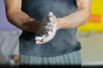 Obraz na płótnie Canvas Closeup image of male hands near a climbing wall