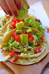 Eating three fish tacos with fresh salsa and avocado