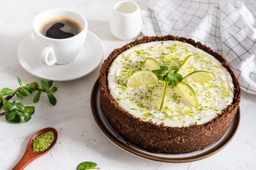 Homemade cheesecake with lime and mint for dessert - healthy organic summer dessert pie cheesecake. Cheese cake with a cup of coffee on white background