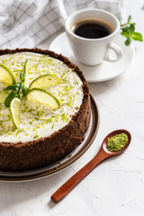 Lime cheesecake with peppermint. Cheesecake with cup of coffee on white background. Top view