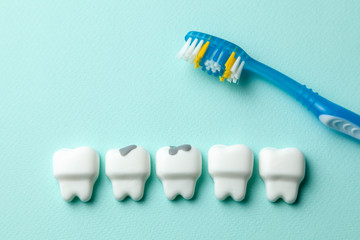 Healthy white teeth and tooth with caries on green mint background and Toothbrush.