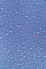 Beautiful water drops of the correct form on a gentle  blue background