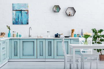 interior of turquoise and white elegant kitchen with kitchenware and decor