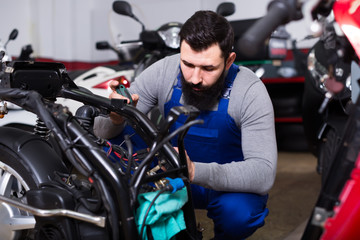 Fototapeta na wymiar diligent man worker working at restoring motorbike in workshop
