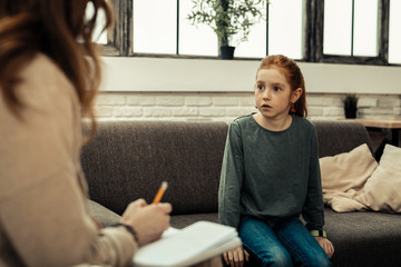 Nice worried girl looking at the psychologist