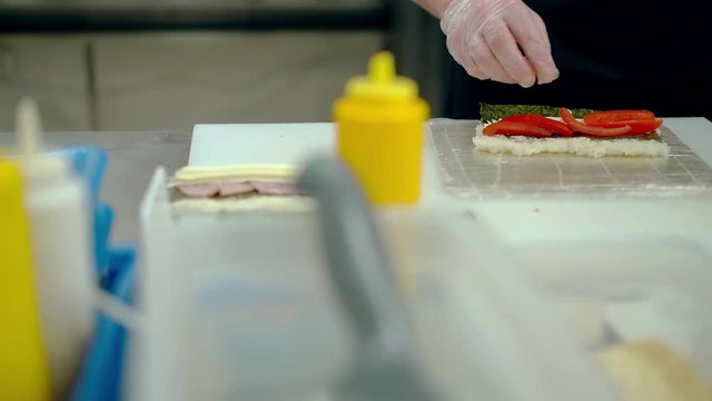 Cook prepares Japanese roll with cream and Bulgarian pepper.