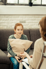 Pleasant nice girl sitting with a cushion