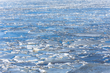 Spring ice drifting on the river on a sunny day. Background texture.