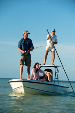 Garry Turner casts his line as Anna Carradice-French watches as they fish off of Key West, Florida. Chris Robinson pilots the boat.