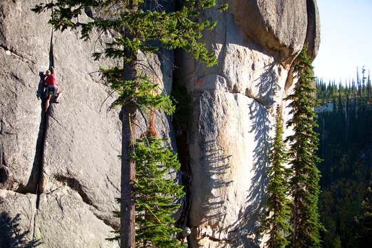 A male rock climber ascends a route in the traditional style, Lolo, Idaho.