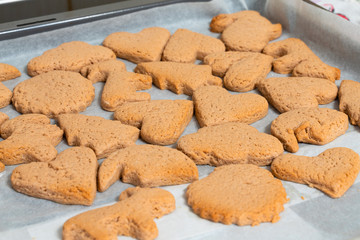fresh baking cookies of different shapes on a baking sheet close-up