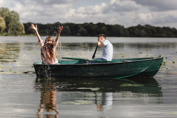 Feeling playful. Beautiful young couple enjoying romantic date while rowing a boat. Happy to have each other.