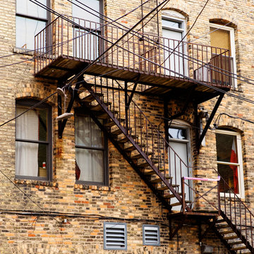 Metal stairs on the back of a old brick building.