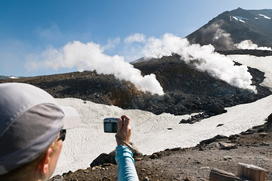 Woman photographing steaming fumaroles, Mt Asahi-dake (2290 m), Hokkaido, Japan, on the 19 June 2010. Mt Asahi-dake is the highest point in Hokkaido and is an active volcano.