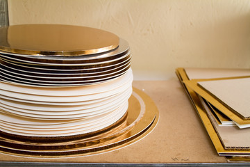 Gold and white coasters for cakes, rings for decorating cakes, baking tools.