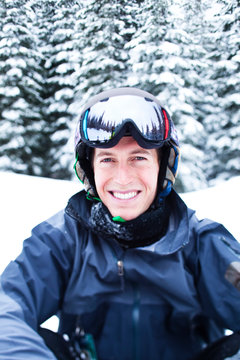 Portrait of young man in winter, wearing helmet and ski goggles 