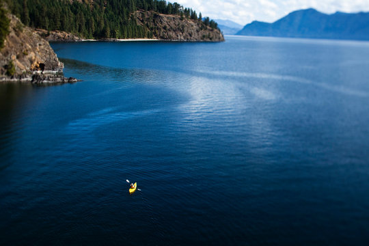 A athletic woman kayaking on Lake Pend Oreille in Sandpoint, Idaho.