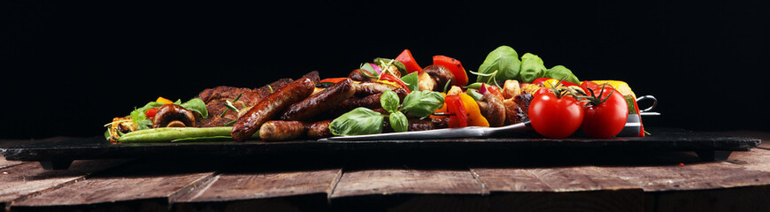 Assorted delicious grilled meat and skewer with vegetable on rustic table
