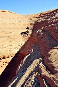A mountain biker descends an extremely steep line on sandstone near Moab, UT.