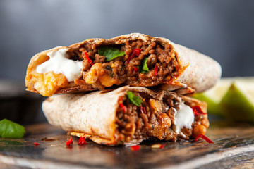 Mexican burrito with beef, beans and sour cream - obrazy, fototapety, plakaty