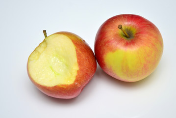Angebissener Apfel mit weiterem Apfel in rot-hellgrüner Färbung
