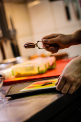 The chef cooking chicken wings in a sauce in the kitchen. Decorating the dishes with colored blobs. Lymon. Chicken. Sauce with honey and seasonings