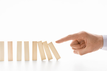 Male hand pushing dominoes on white background