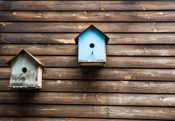 wooden bird boxes or birdhouses on a wooden wall, background texture