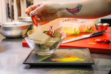 The chef cooking chicken wings in a sauce in the kitchen. Decorating the dishes with colored blobs. Lymon. Chicken. Sauce with honey and seasonings