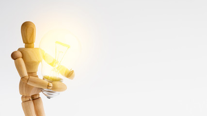 Mannequin holding glowing light bulb, copy space