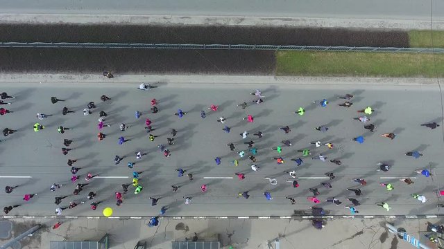 aerial top down shot of crowd of athletic people running at city marathon