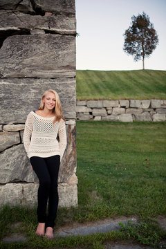 A young woman stands against a wall at the old armory in Augusta, Maine.