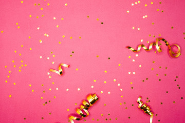 Golden decorations and sparkles on pink background