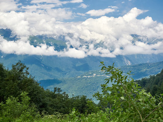 Green mountain slope with serpentine road that descends into the valley.