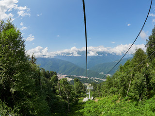 The cable car descends along the green mountain slope