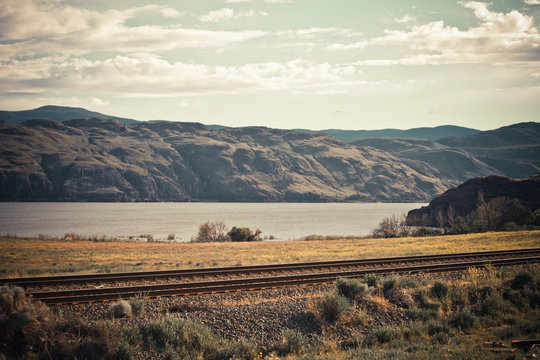 Two sets of railway line run parallel with Kamloops Lake, British Columbia, Canada.