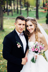 Great portrait of a wedding couple, which is walking in the park.