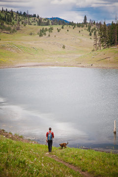 A fisherman and his dog approach Deep Lake after hiking into the lake which is near Kamloops, British Columbia, Canada.