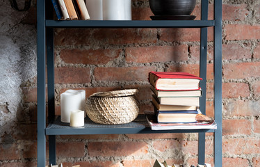 Metal bookcase with books on brick wall background
