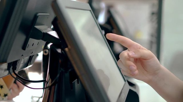 Cashiers are working, touching touch screen, choosing the right products.