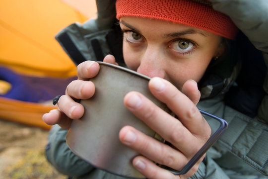 Woman sipping hot beverage during camping trip