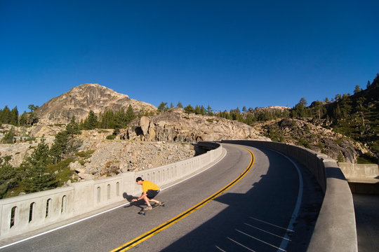 Man skateboarding on road in California.