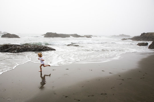 A girl runs in circles on California's northern coast as the fog begins to move in.